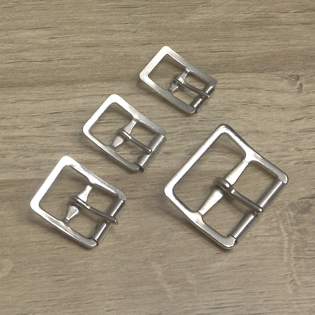 Four nickel-plated centre bar roller buckles side by side, from 13mm up to 32mm