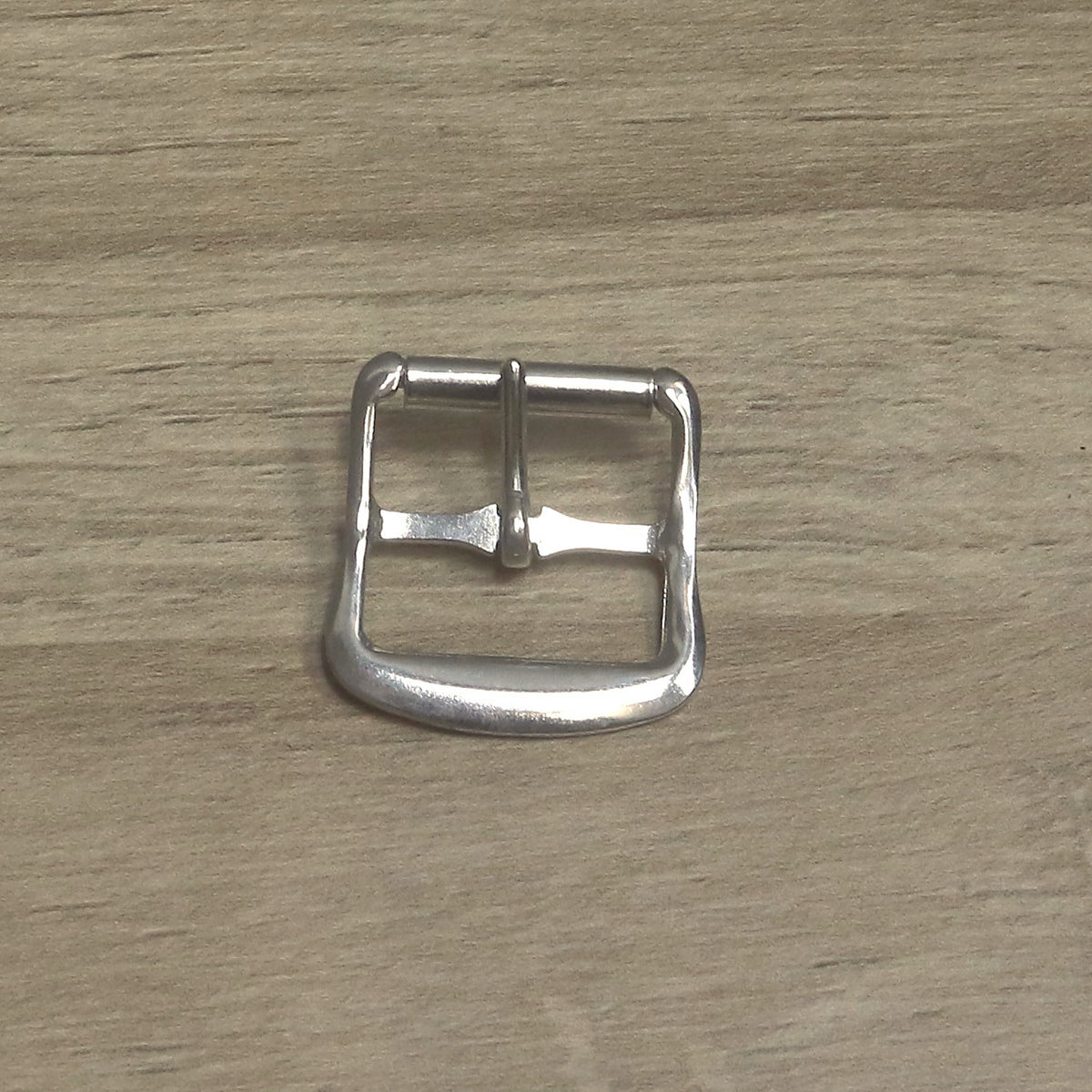 Nickel-plated roller buckle upright, showing the pin running from the centre bar up to the roller