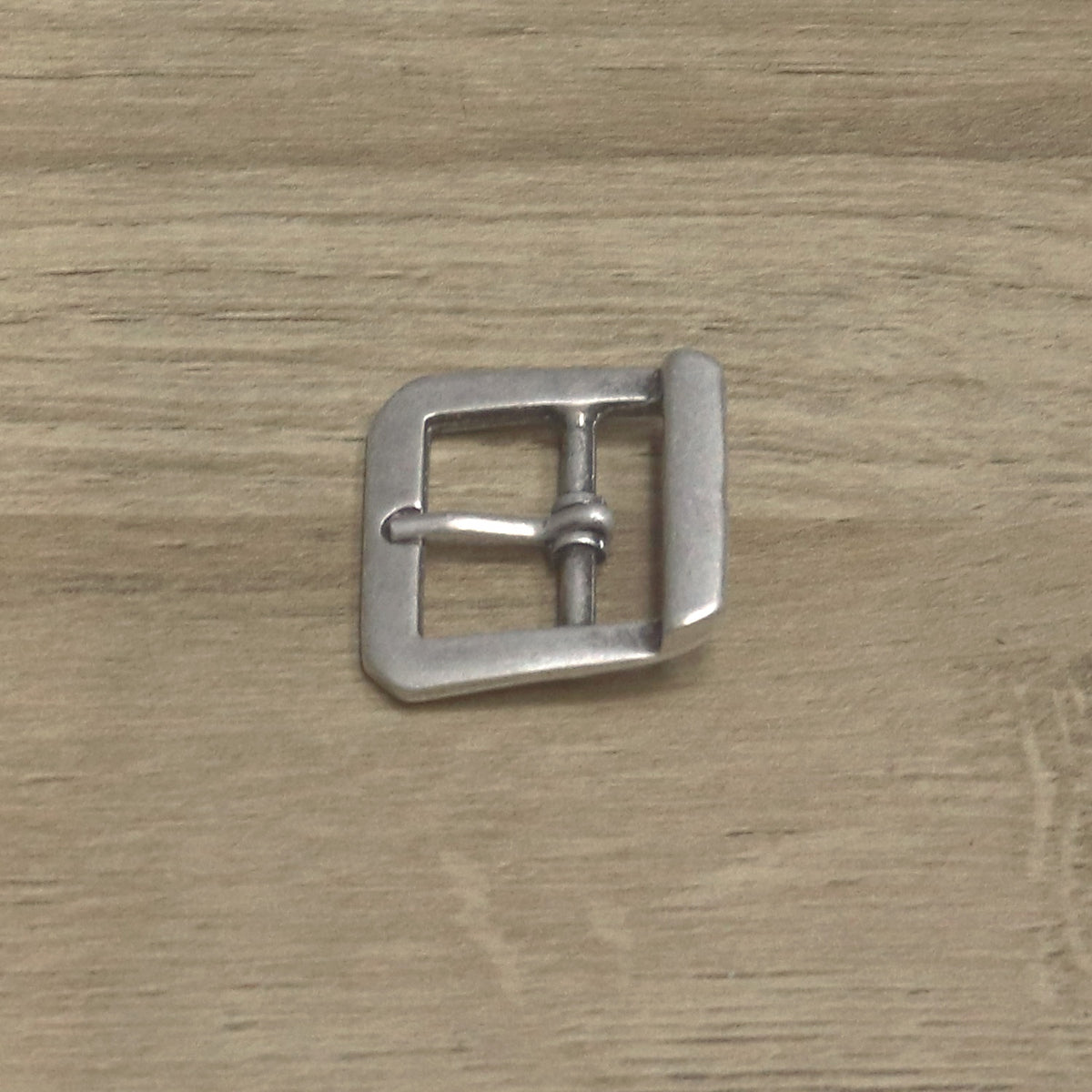 Antique nickel cast centre bar buckle angled, pin resting on the front bar