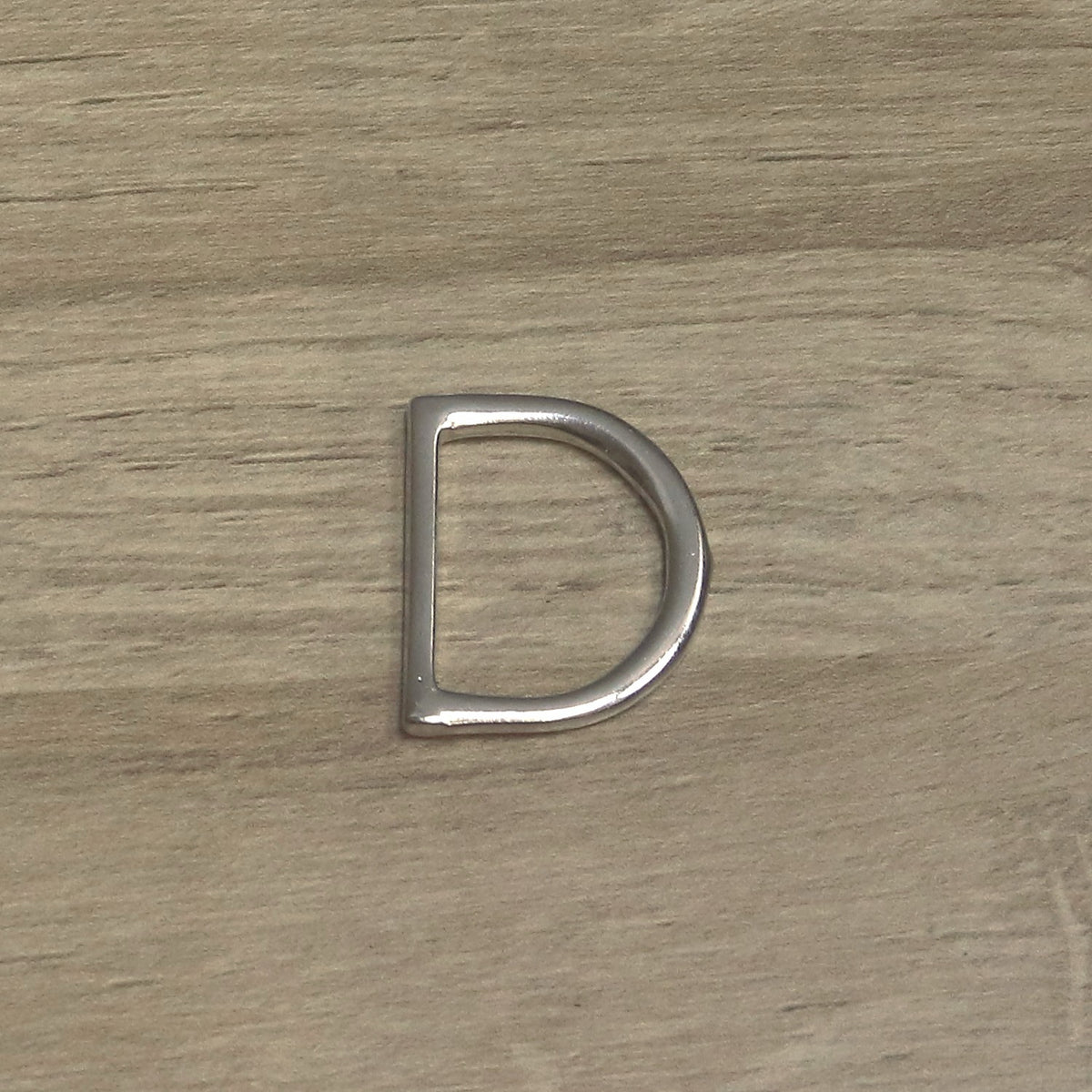 Nickel-plated one-piece D ring from above, flat straight bar on the left