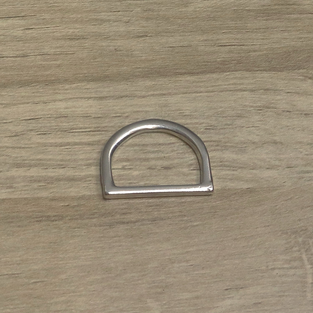 Nickel-plated one-piece D ring with the square-edged straight bar along the bottom