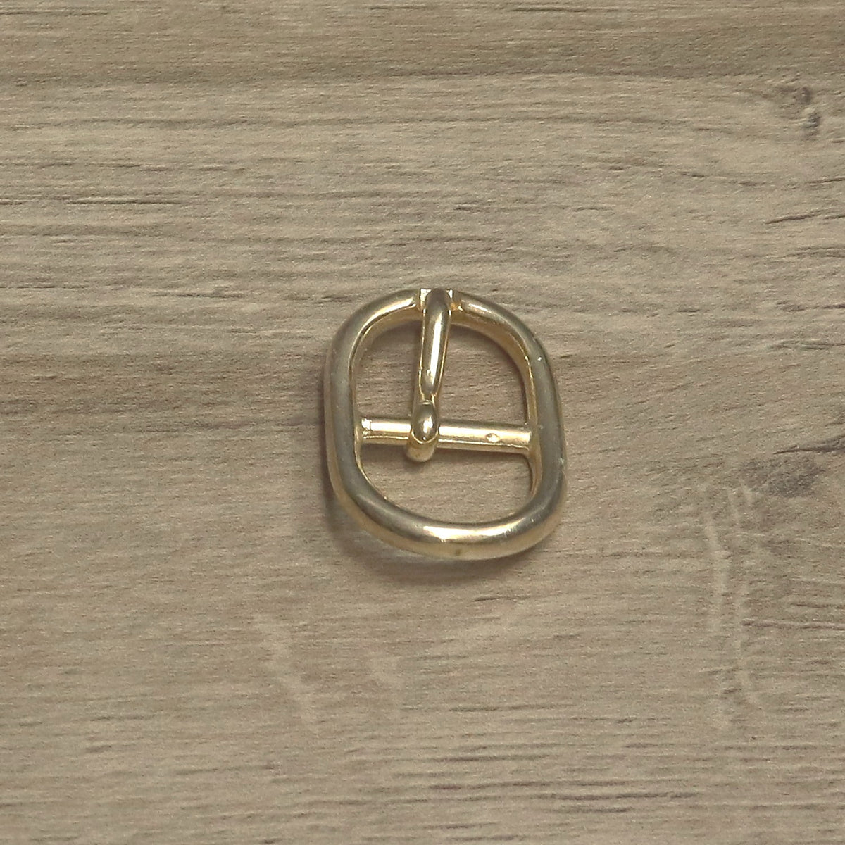 Brass-plated centre bar buckle with the pin resting on the centre bar
