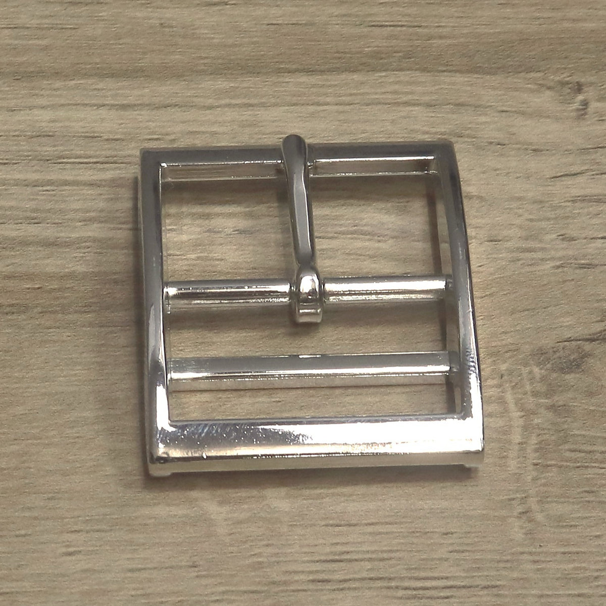 Nickel-plated double bar buckle from above, showing the pin bar and the keeper bar