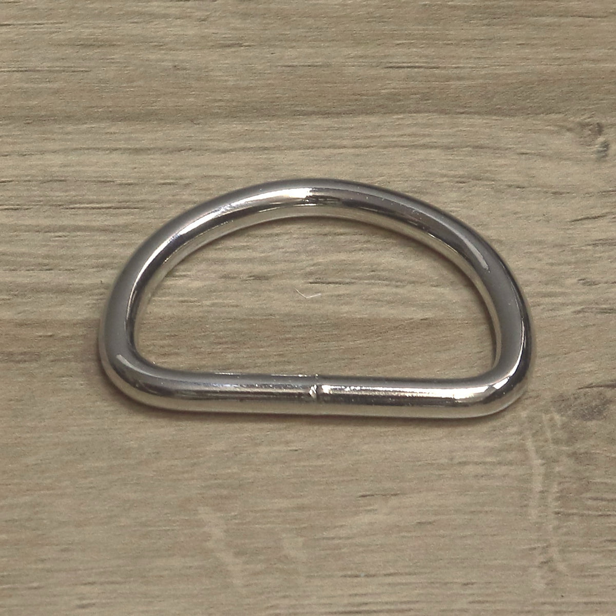 Nickel-plated heavy D ring in 6mm wire for a 50mm strap, from above with the welded join on the straight side