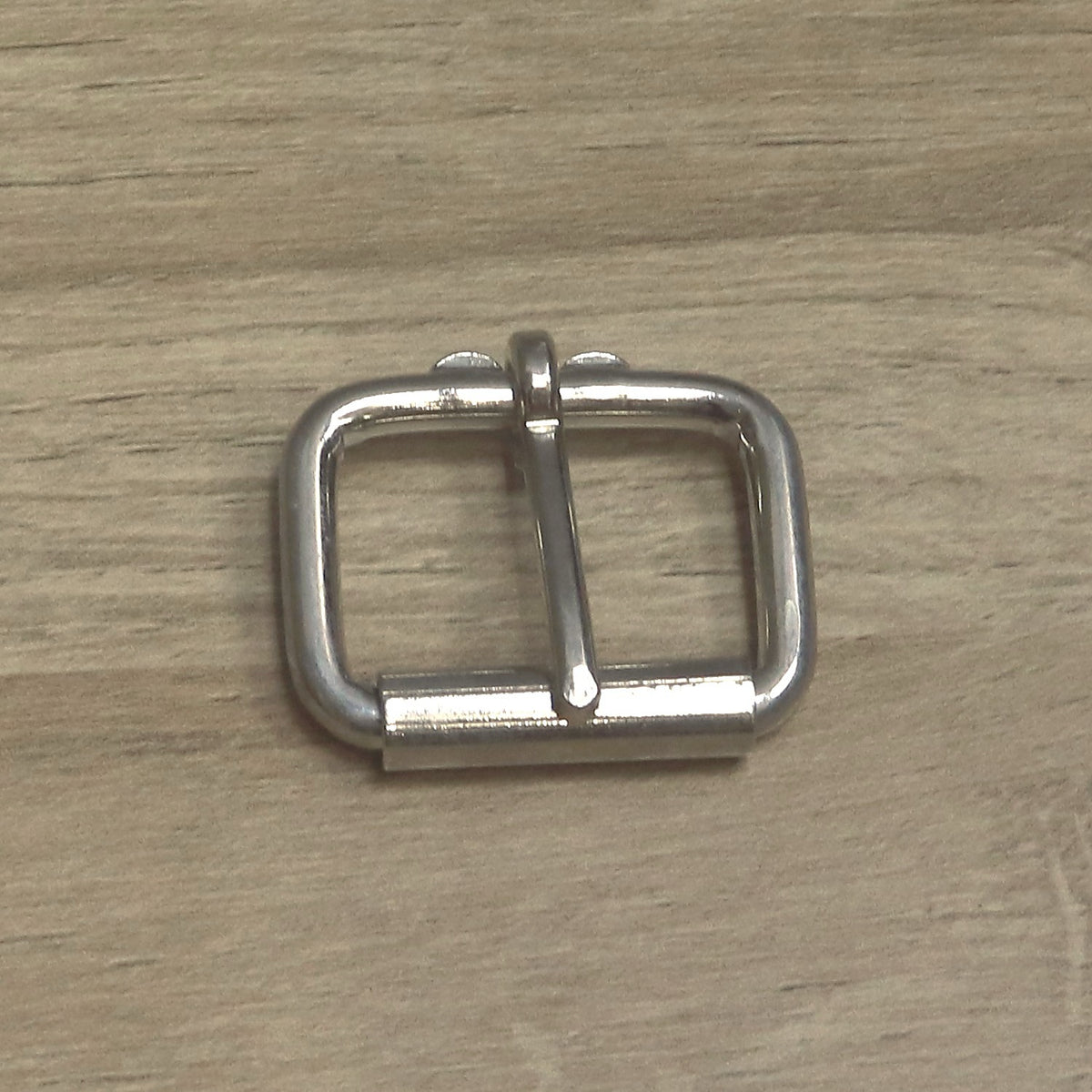 Nickel-plated heavy wire roller buckle from above, roller along the bottom bar and pin hinged at the top