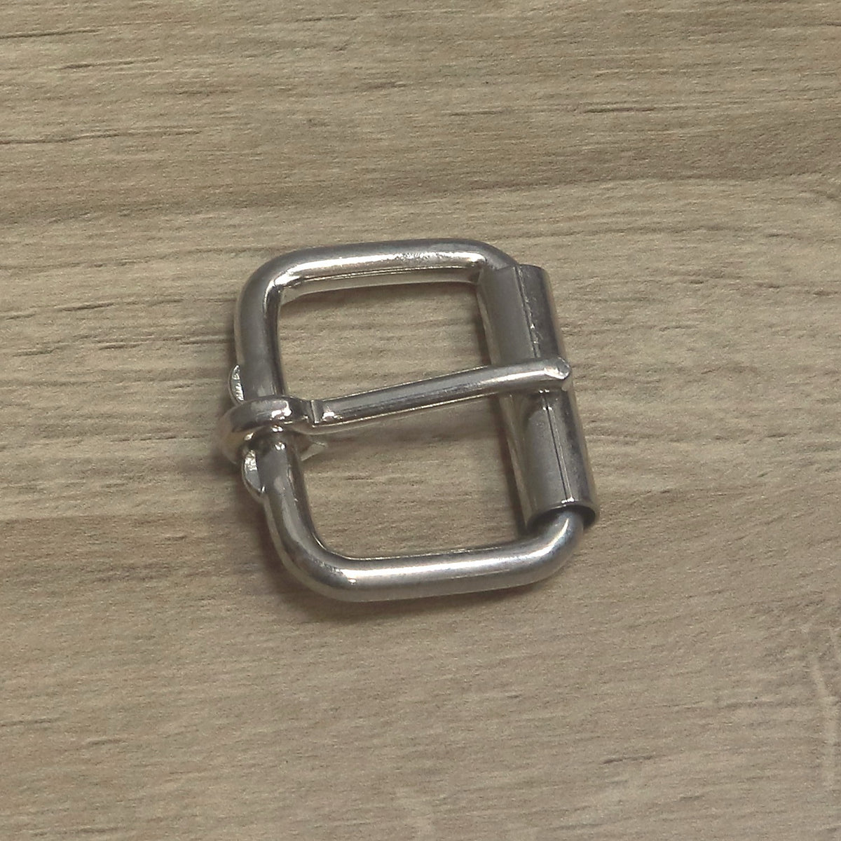 Nickel-plated heavy wire roller buckle side on, showing the pin between its two stops on the back bar