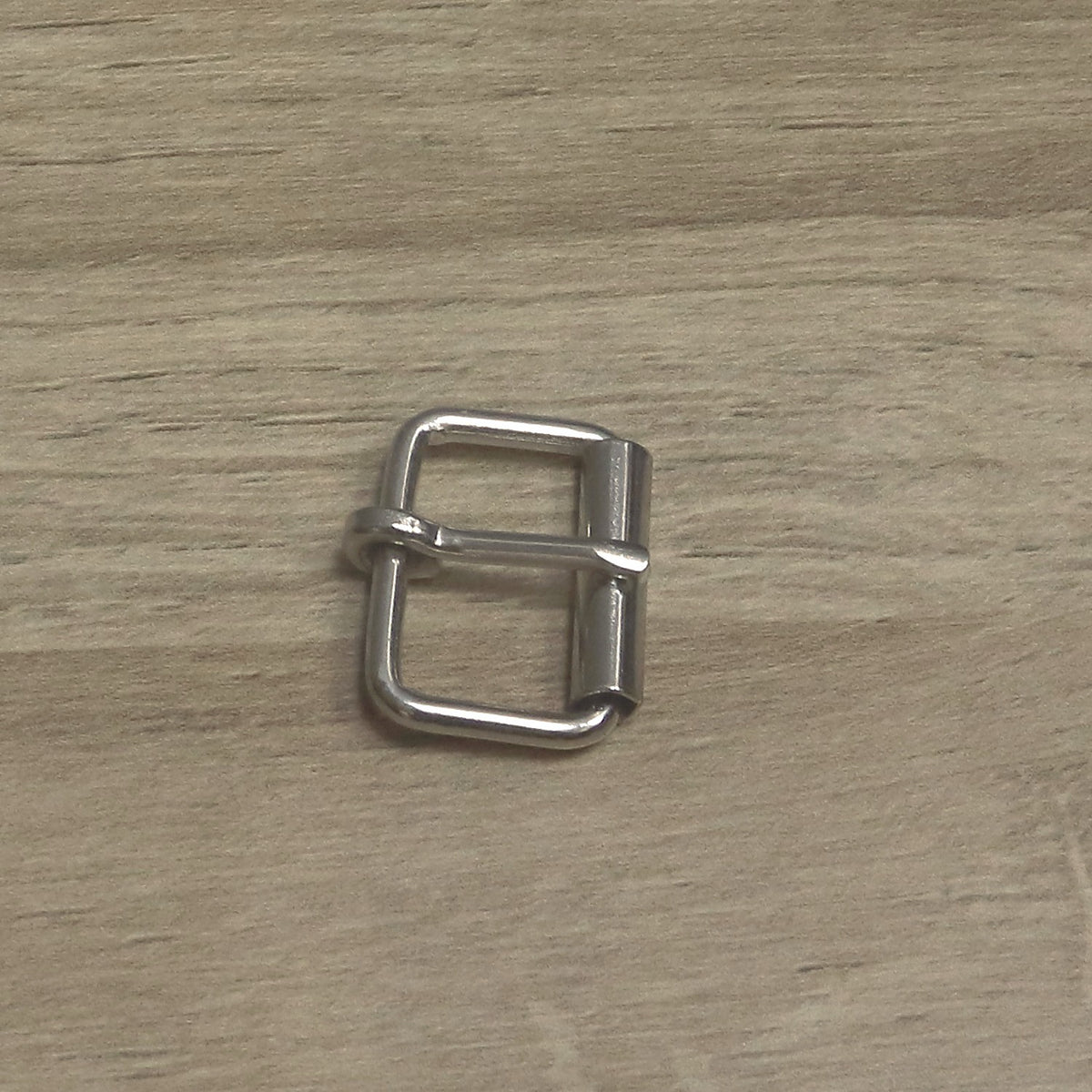Nickel-plated 25mm wire roller buckle from above, roller on the right and pin looped round the back bar