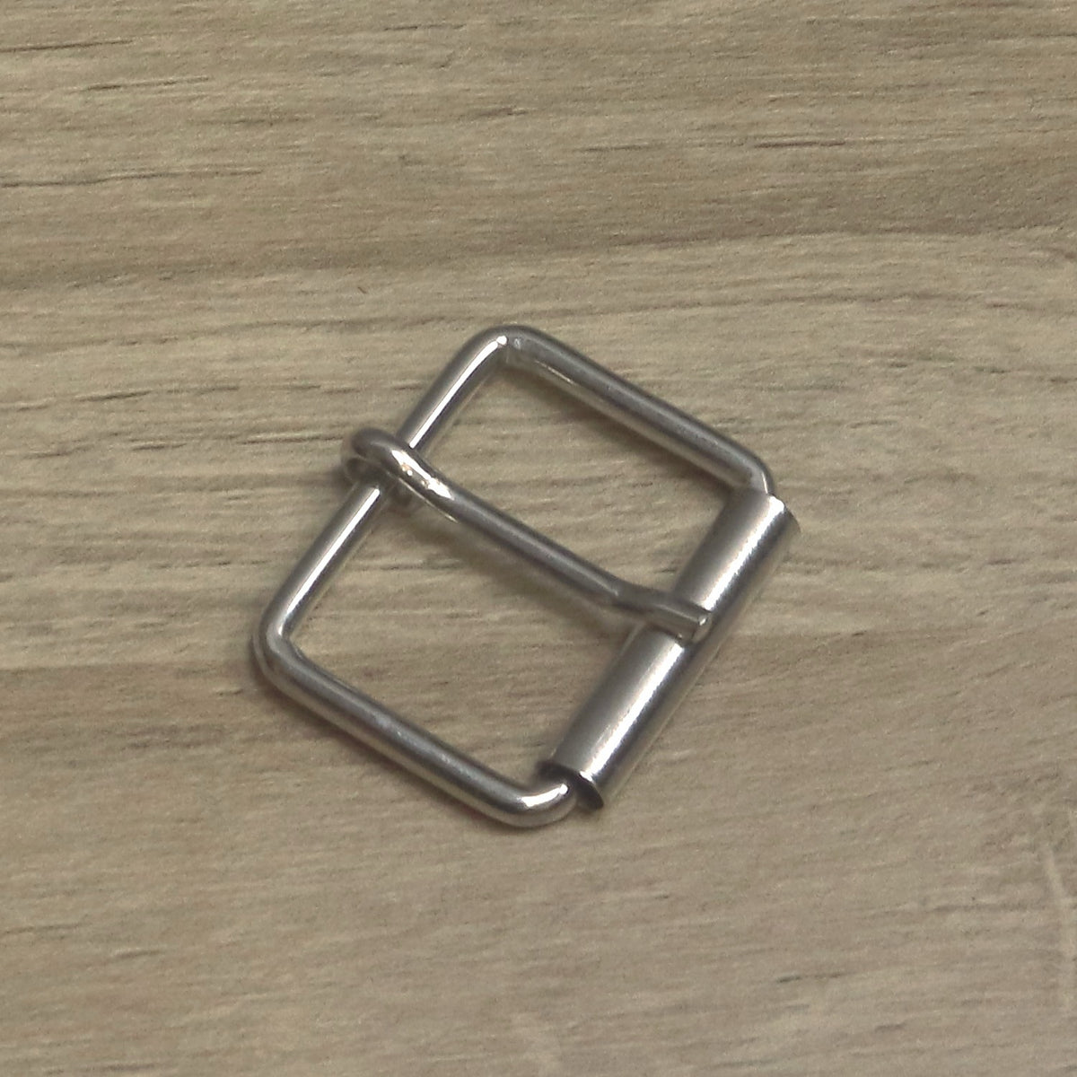 Nickel-plated wire roller buckle at an angle, pin resting on the roller