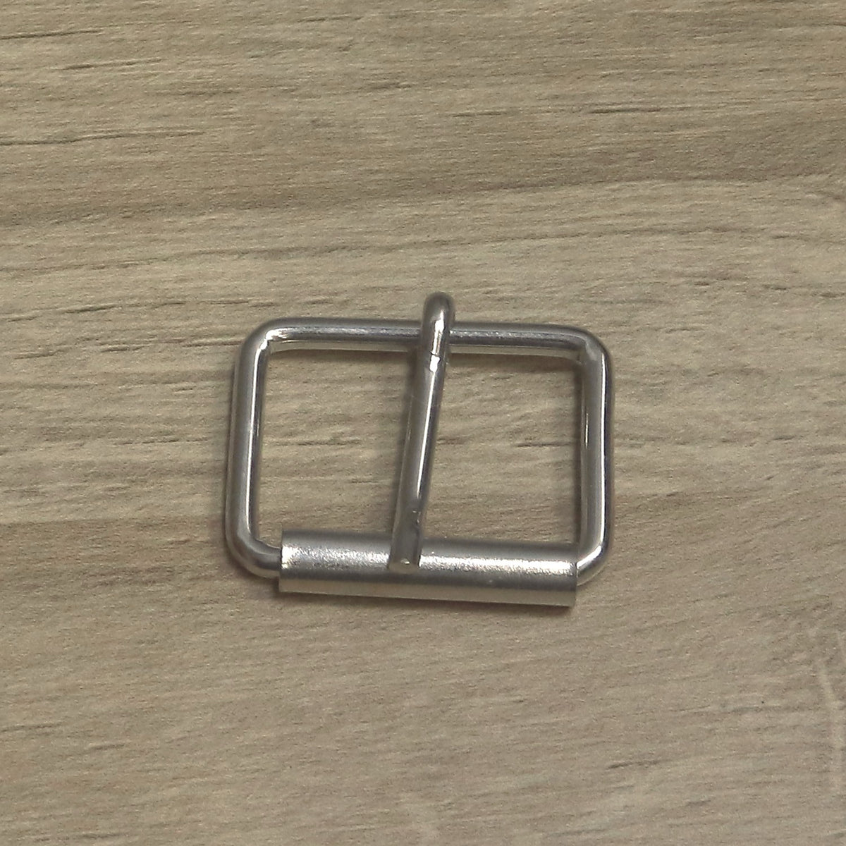 Nickel-plated wire roller buckle from above, roller along the bottom bar and pin pointing up