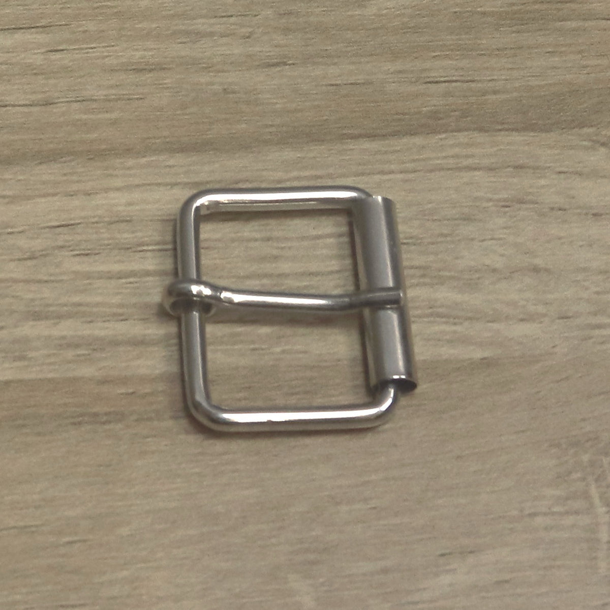 Nickel-plated wire roller buckle from above, showing the pin looped round the back bar
