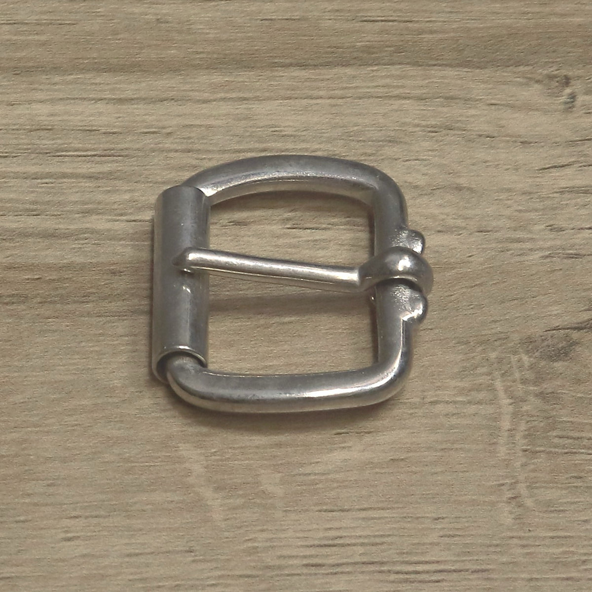 Nickel-plated roller buckle for a 32mm strap, roller to the left and pin resting across the frame
