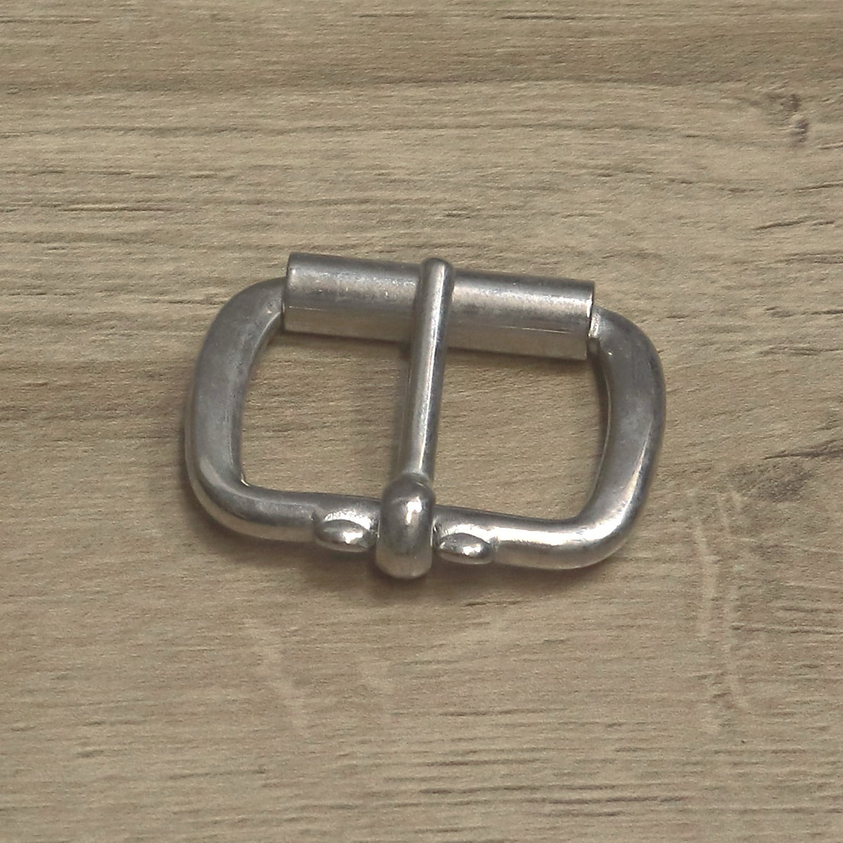 Nickel-plated roller buckle with the pin hinged on the back bar between two stops
