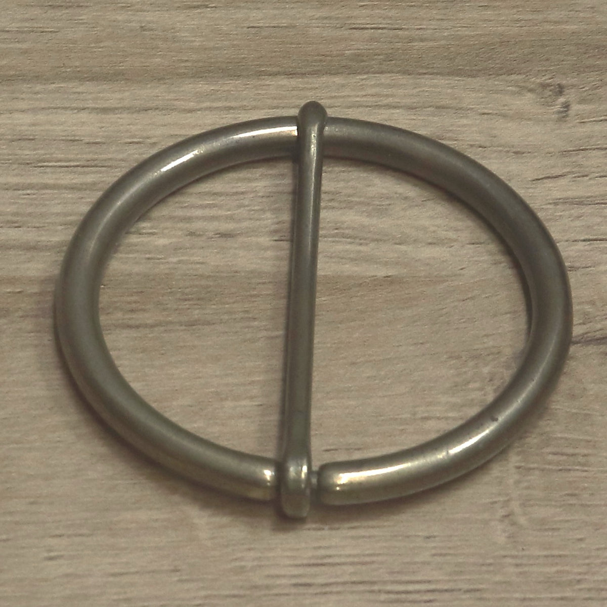 Round buckle from above with the pin upright, showing the hinge on the ring