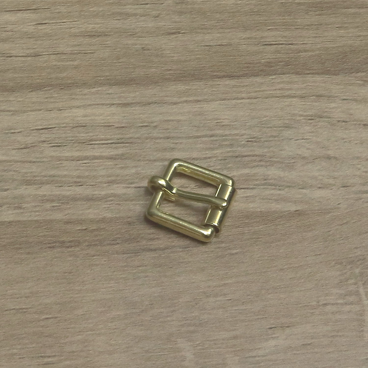 Small brass buckle turned at an angle, showing the square wire frame