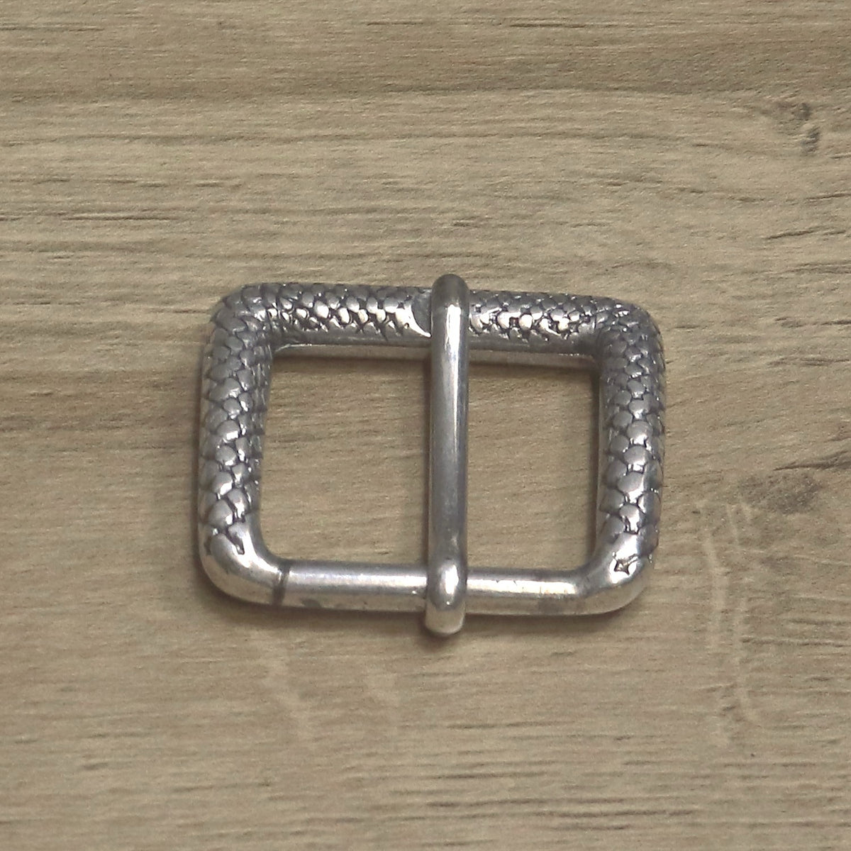 Antique nickel textured roller buckle from above, pin towards the camera