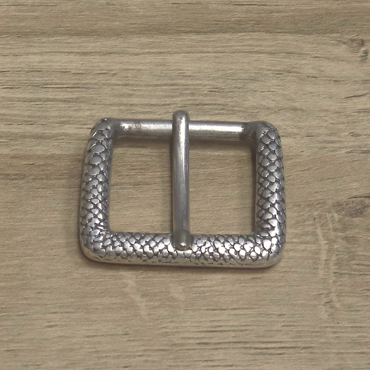 Textured roller buckle from above, showing the scale pattern on the frame