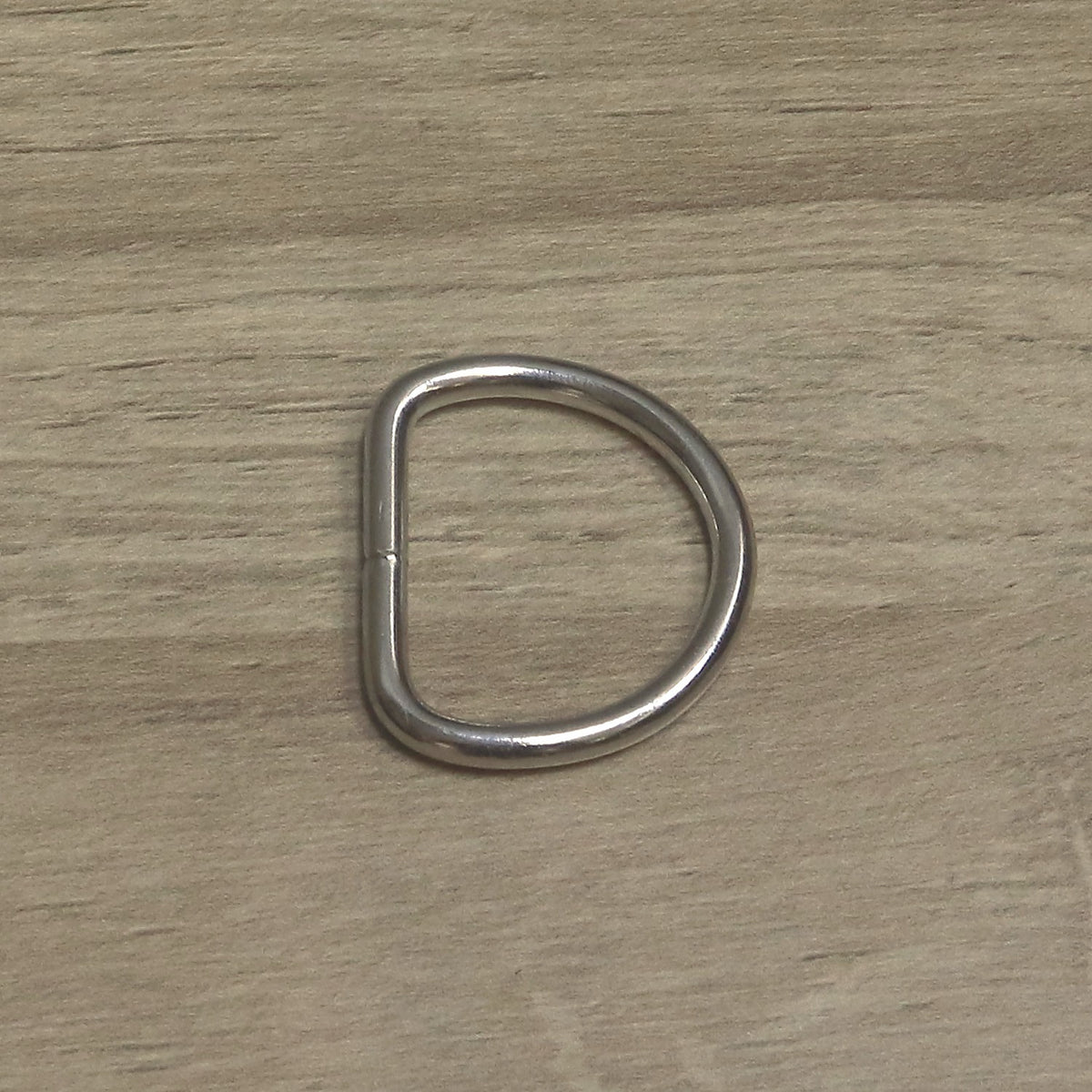 Nickel-plated welded D ring in 4mm wire for a 30mm strap, from above with the welded join on the straight side