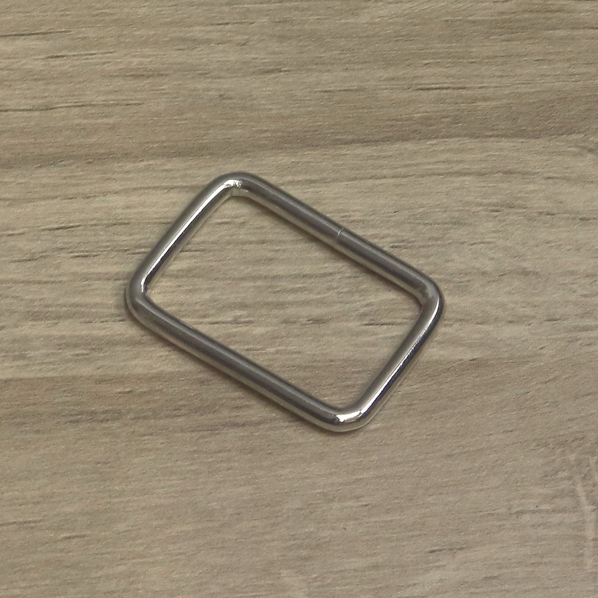 Nickel-plated rectangle ring turned at an angle to show the rounded corners