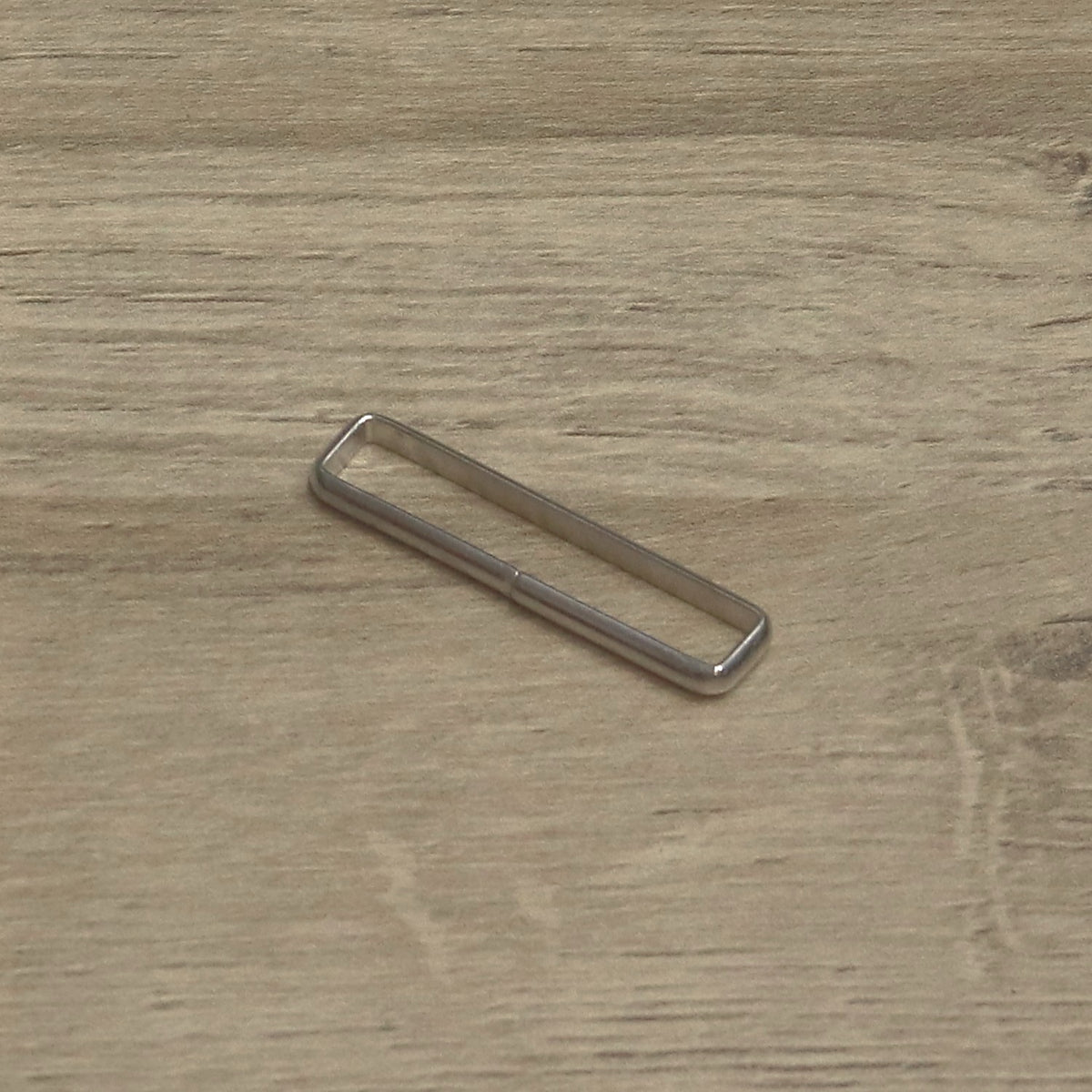 Nickel-plated wire keeper loop angled to show the rectangular wire frame