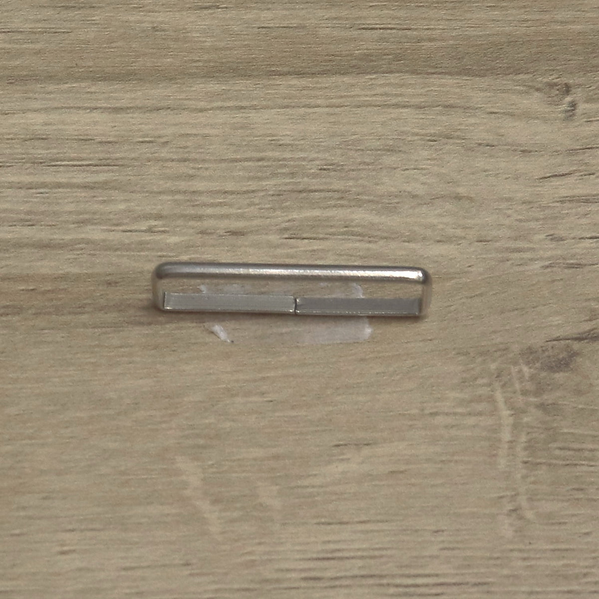 Nickel-plated wire keeper loop on its edge, showing the join in the wire